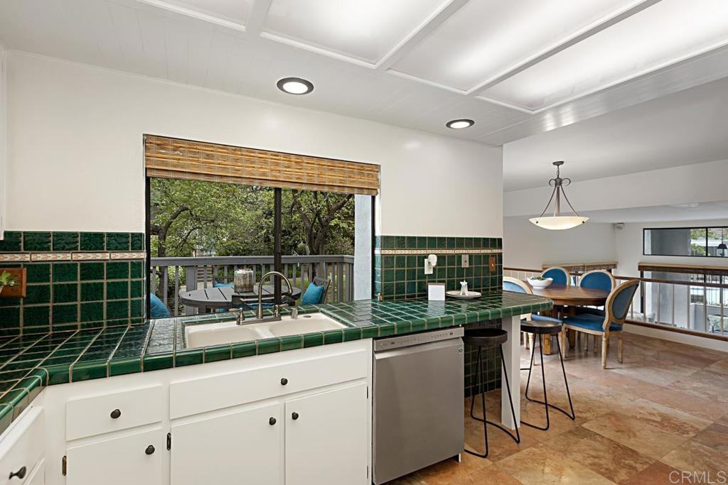 3242 Via Alicante La Jolla, CA 92037 - Photo 11 of 27 a kitchen with granite countertop a stove a sink a dining table and chairs