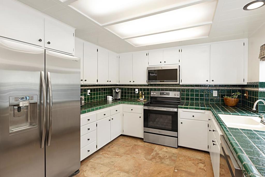 3242 Via Alicante La Jolla, CA 92037 - Photo 10 of 27 a kitchen with granite countertop a refrigerator stove and white cabinets