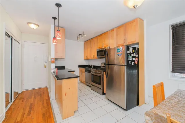 a kitchen with stainless steel appliances granite countertop a refrigerator and a stove