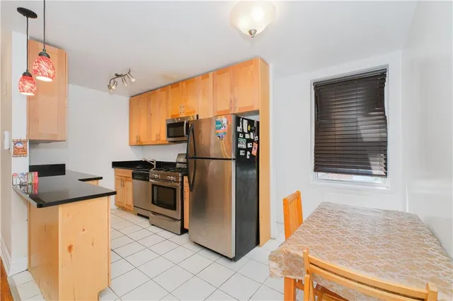 a kitchen with stainless steel appliances granite countertop a refrigerator and a stove