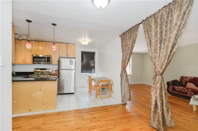 a kitchen with stainless steel appliances granite countertop a refrigerator a stove a sink dishwasher and a refrigerator with wooden floor