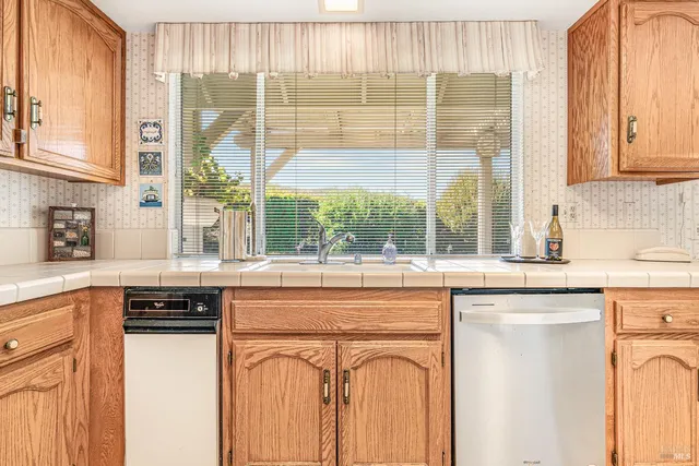a kitchen with stainless steel appliances granite countertop a stove and a white cabinets