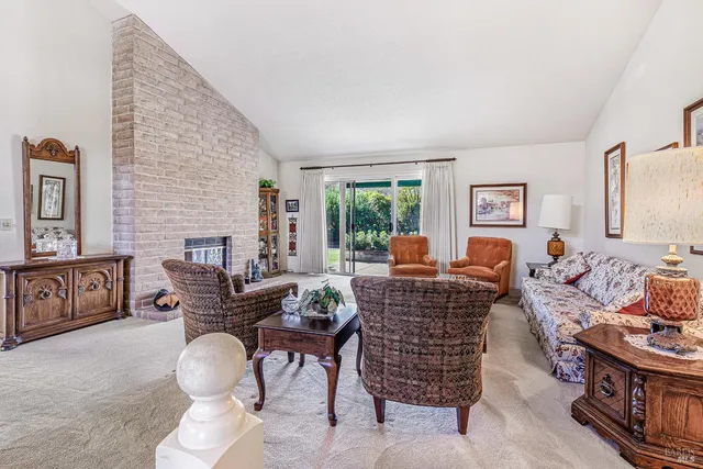 a living room with furniture a chandelier and a dining table