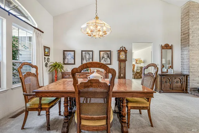 a dining room with furniture a chandelier and a rug