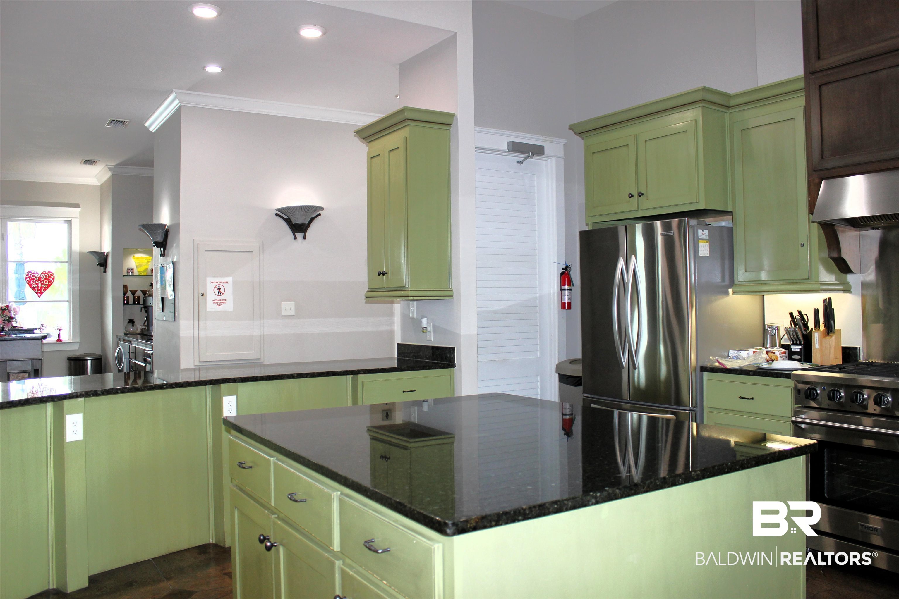11993 Gateway Drive Elberta, AL 36530 - Photo 19 of 44 Kitchen with green cabinetry, a center island, dark stone countertops, ornamental molding, and appliances with stainless steel finishes