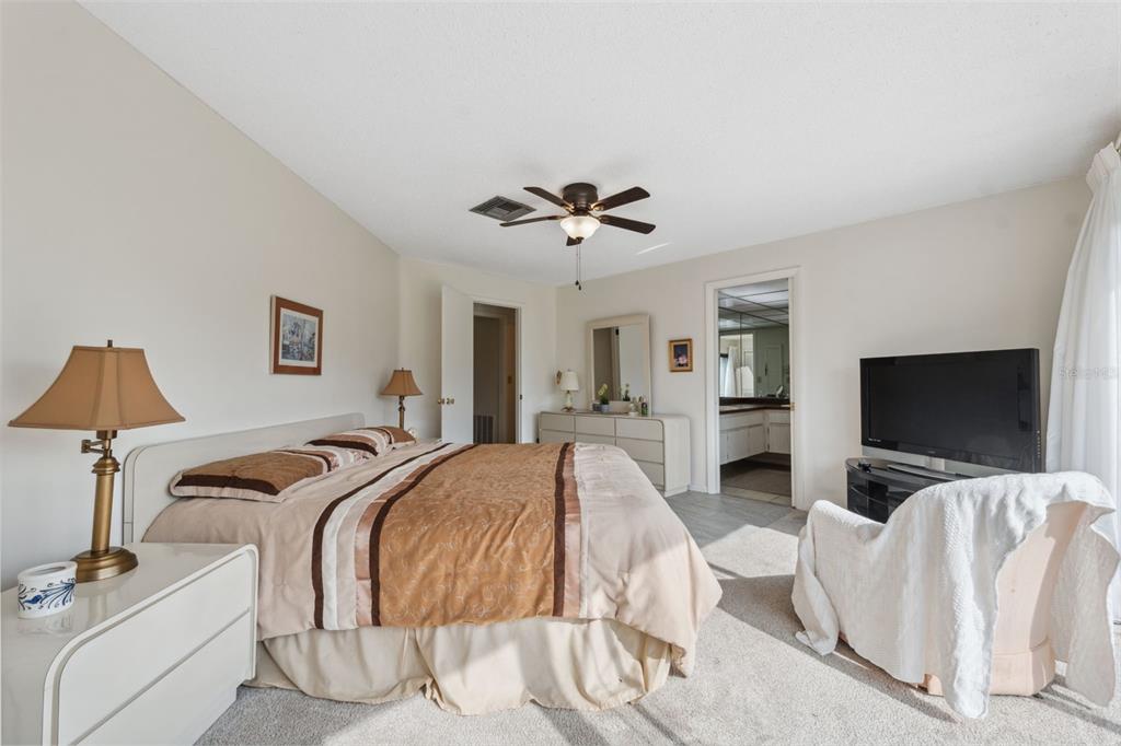 3942 Trophy Boulevard New Port Richey, FL 34655 - Photo 25 of 78 a spacious bedroom with a bed and a flat screen tv