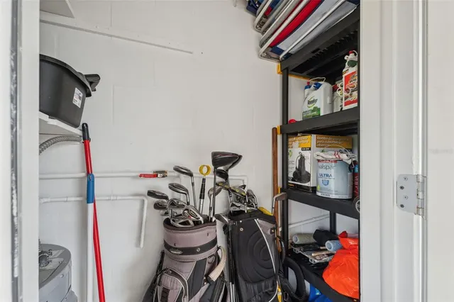 a view of a patio with a table and chairs under an umbrella with palm trees