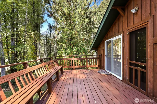 a view of a balcony with chairs and wooden floor