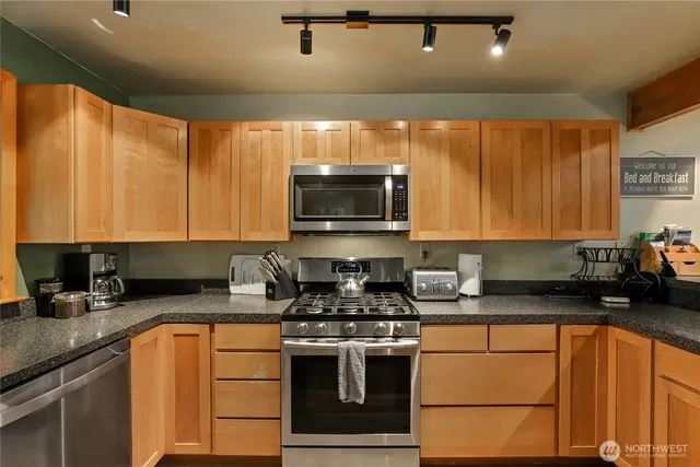 a kitchen with a table chairs microwave and cabinets