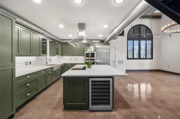 a kitchen with kitchen island a sink stainless steel appliances and cabinets