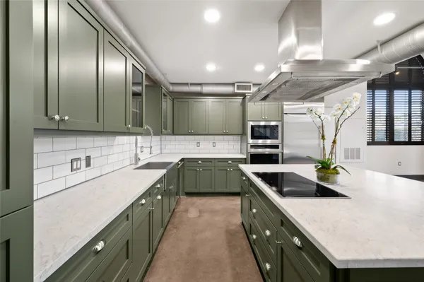 a kitchen with stainless steel appliances granite countertop a sink a stove and cabinets