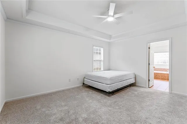 an empty room with window and ceiling fan