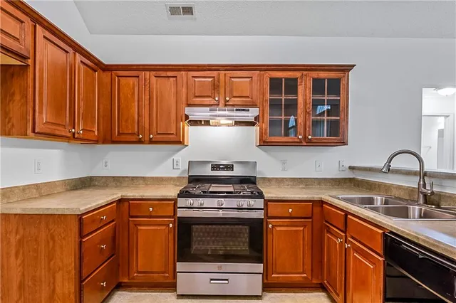 a kitchen with stainless steel appliances a stove a sink and a microwave