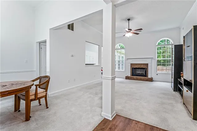 an empty room with windows fireplace and a chandelier