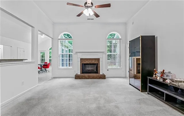 a view of an empty room with a fireplace and a window