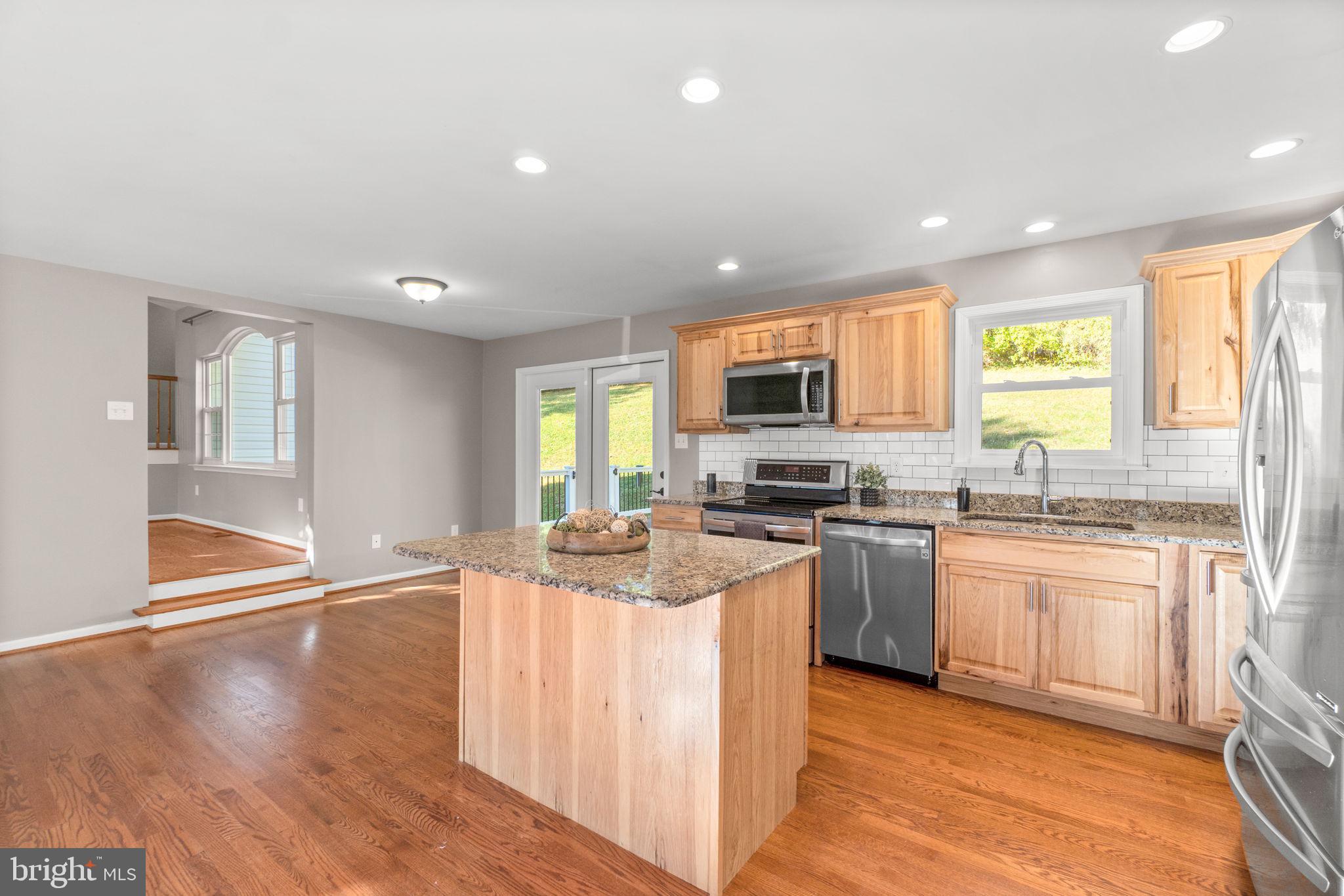 1414 Old New Windsor Road New Windsor, MD 21776 - Photo 2 of 10 a kitchen with stainless steel appliances granite countertop a stove top oven a sink dishwasher and a refrigerator