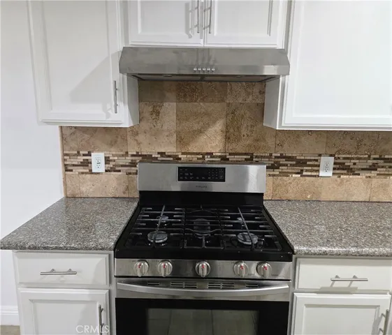 a white stove top oven sitting inside of a kitchen