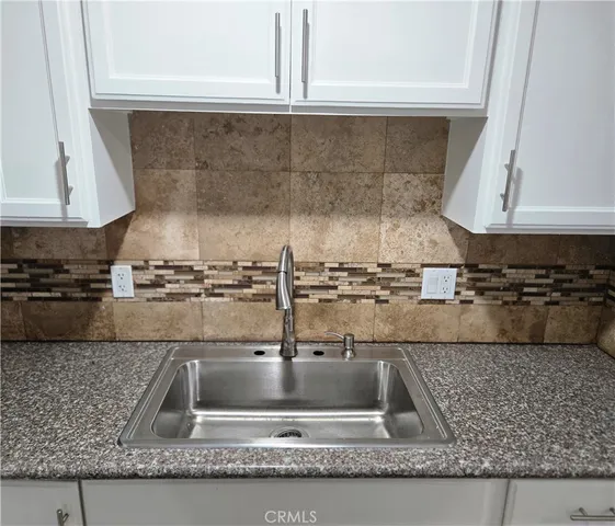 a kitchen with granite countertop a sink and a stove