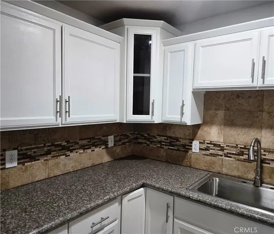 a kitchen with granite countertop a sink and cabinets