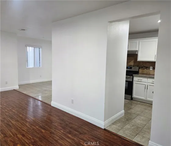 a view of a kitchen with wooden floor and electronic appliances