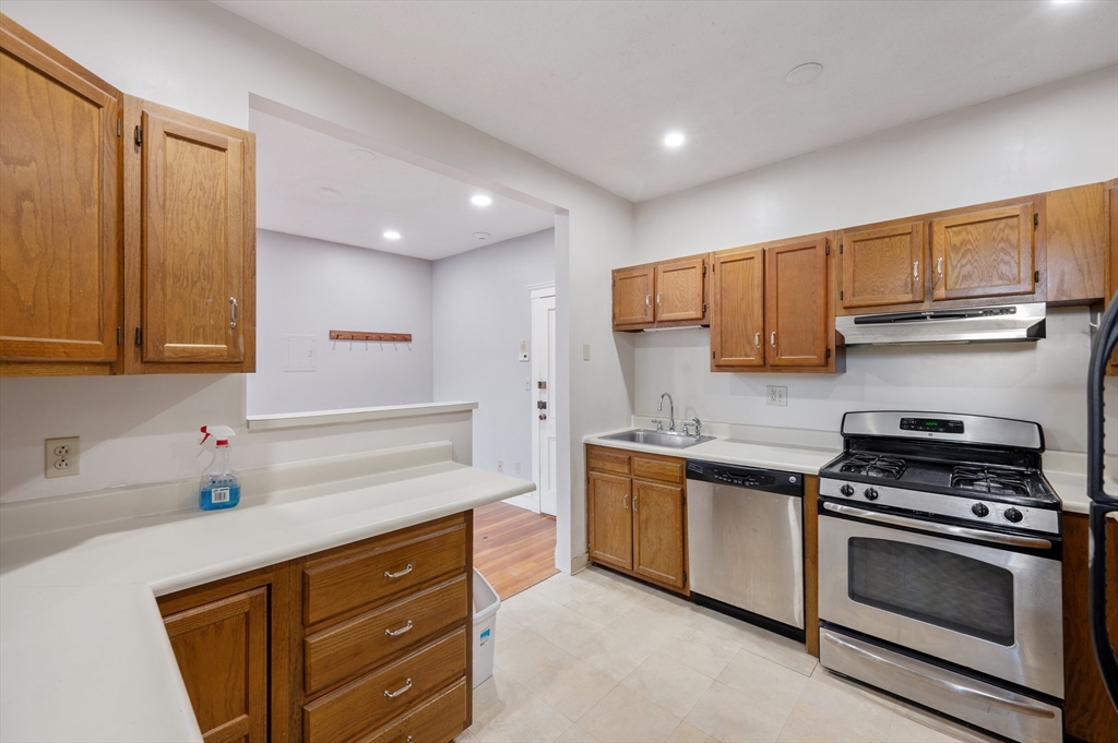 21 Sutherland Road, Unit 15 Boston, MA 02135 - Photo 5 of 13 a kitchen with stainless steel appliances granite countertop a sink stove and cabinets