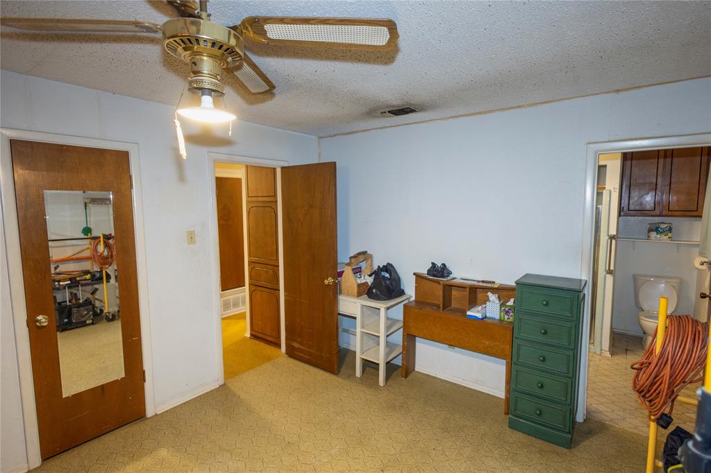 809 Lomo Street Fort Worth, TX 76110 - Photo 20 of 31 a bedroom with a bed and a chandelier