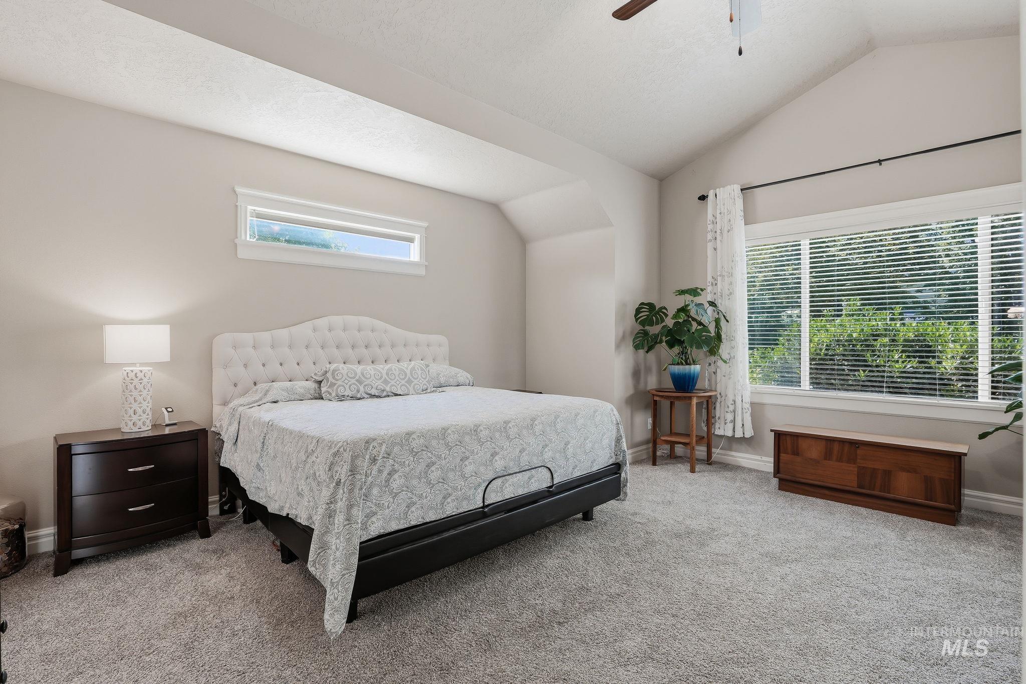 3969 North Hollymount Way Meridian, ID 83646 - Photo 21 of 47 Carpeted bedroom with a vaulted ceiling, a large window featuring blinds, and an additional horizontal transom window