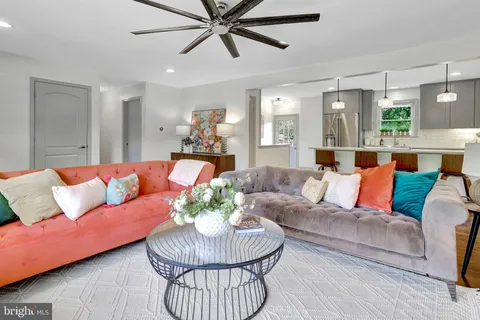 a living room with furniture kitchen and a chandelier