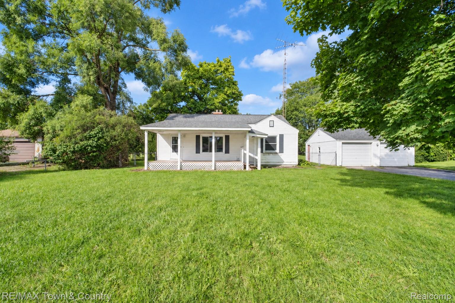 300 Elms Road Flushing, MI 48433 - Photo 2 of 26 White exterior with a covered front porch and dark shutters