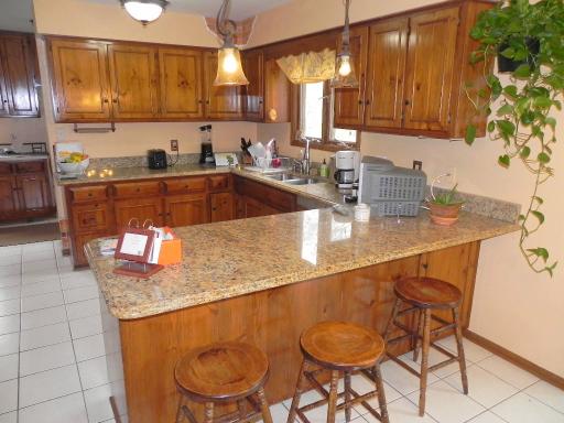 5N485 Oak Road St. Charles, IL 60175 - Photo 7 of 16 a kitchen with stainless steel appliances granite countertop a sink a table and chairs in it