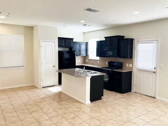 a kitchen with stainless steel appliances granite countertop a refrigerator stove and microwave