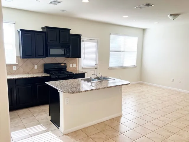 a kitchen with granite countertop a sink and a stove