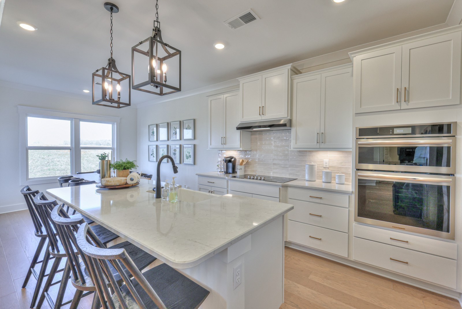 2846 Bluestem Road Columbia, TN 38401 - Photo 10 of 28 a kitchen with stainless steel appliances granite countertop a stove top oven a sink dishwasher a dining table and chairs with wooden floor