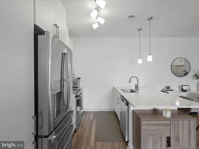 a kitchen with kitchen island a counter top stainless steel appliances and cabinets