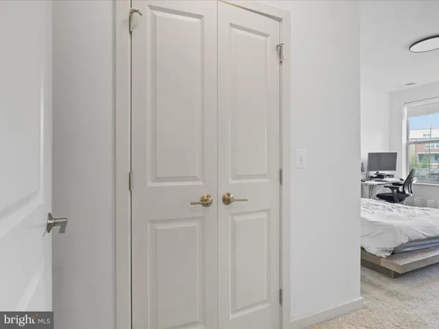 a bed sitting in a spacious bedroom next to a window