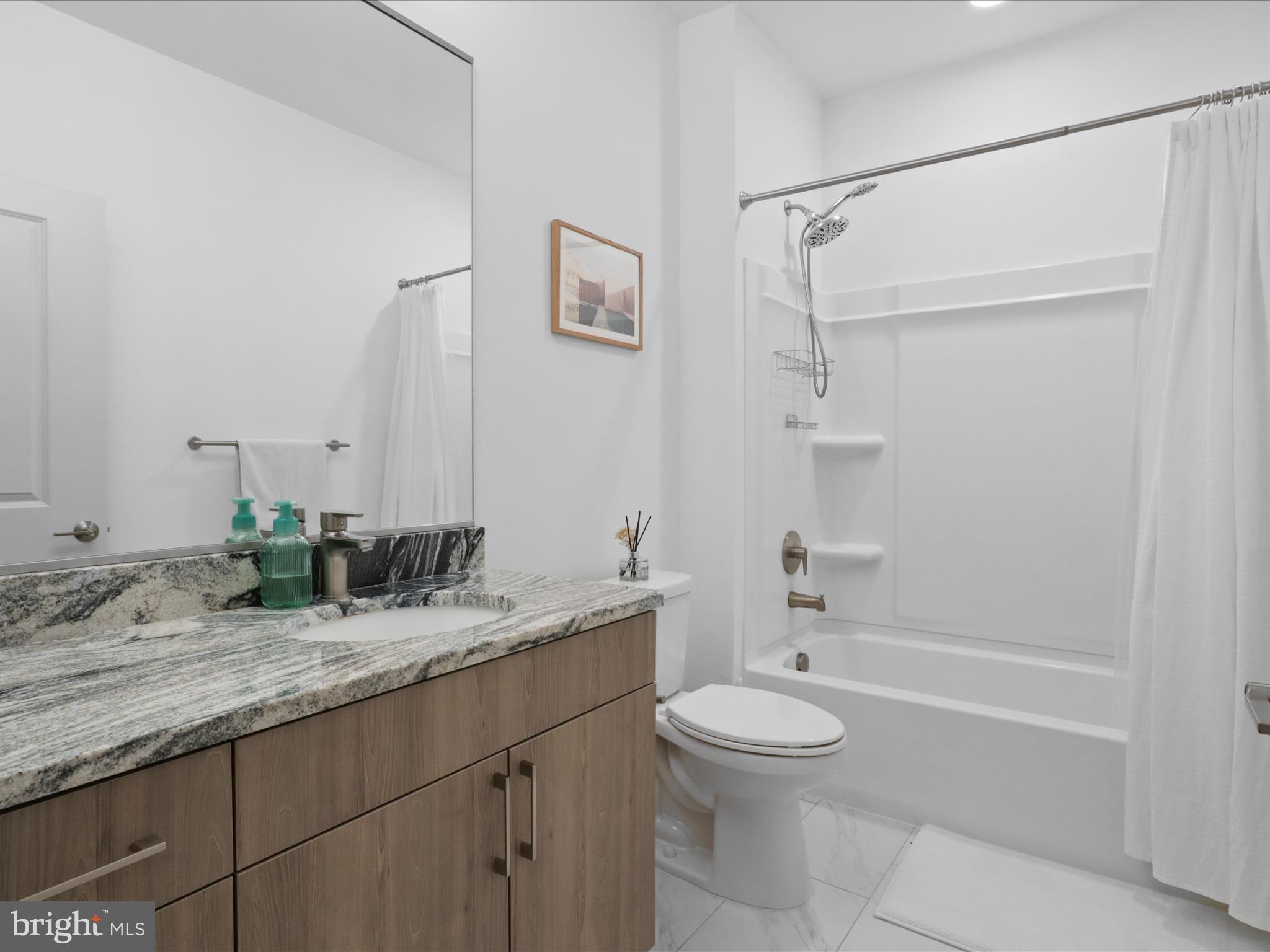 10755 Fairgrounds Drive, Unit 223 Fairfax, VA 22030 - Photo 22 of 28 a bathroom with a granite countertop sink a toilet and shower
