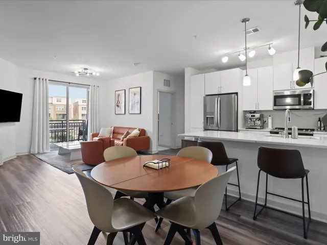 a kitchen with stainless steel appliances granite countertop a kitchen island hardwood floor and a sink