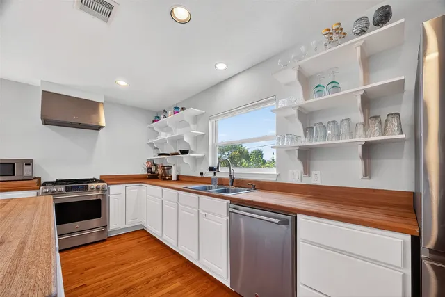 a kitchen with stainless steel appliances granite countertop a sink and stove top oven