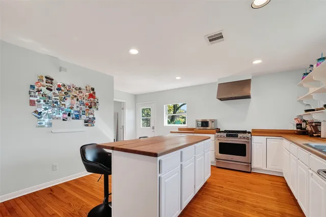 a kitchen with a sink a stove a refrigerator and a dining table