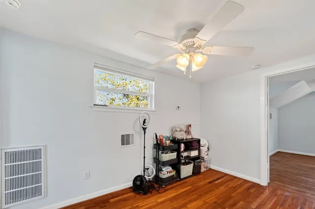 a bedroom with a large bed and a ceiling fan