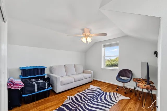 a living room with furniture a flat screen tv and a window