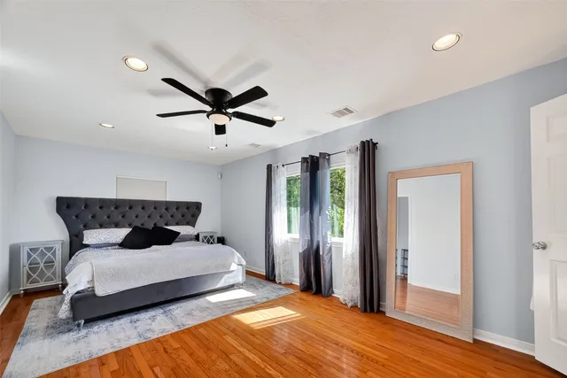 a bedroom with a large bed and a ceiling fan