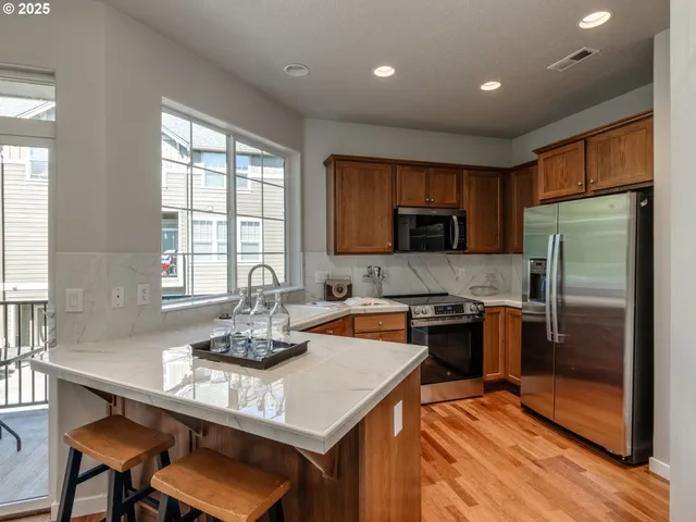 a kitchen with a refrigerator and a stove top oven