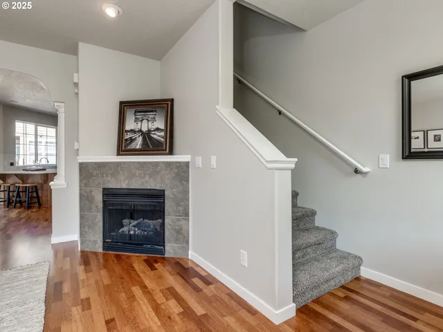 a view of a livingroom with wooden floor and a fireplace