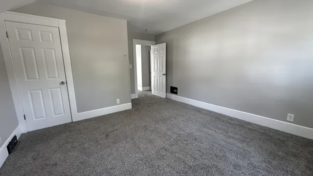 an empty room with windows and closet