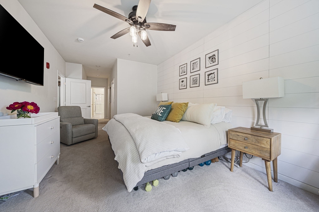 70 Trotter Road, Unit 310 Weymouth, MA 02190 - Photo 6 of 14 a bedroom with a bed flat screen tv and a fireplace