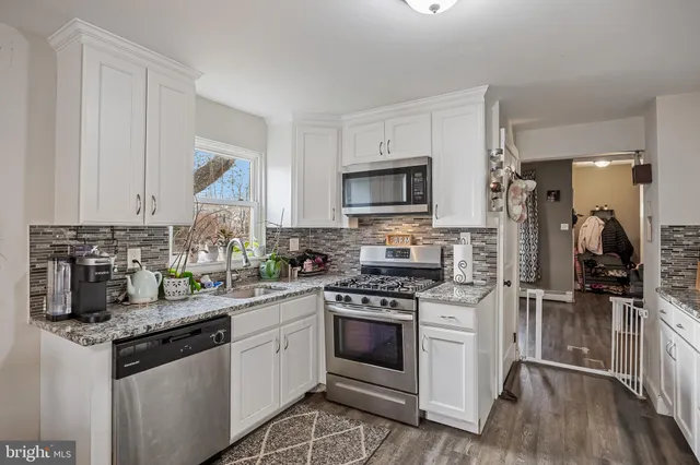 a kitchen with stainless steel appliances granite countertop a stove a sink dishwasher a refrigerator and a microwave