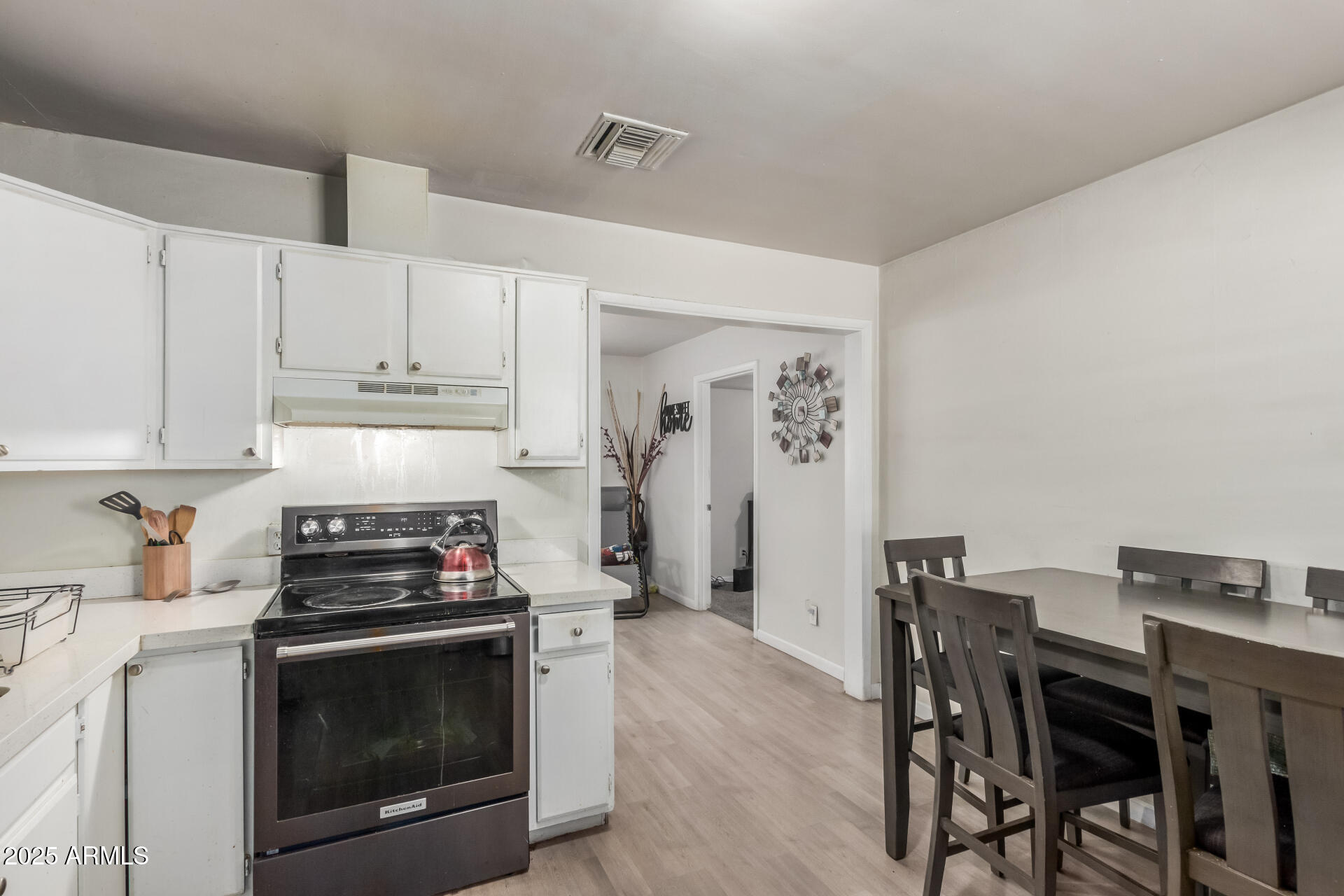 2752 West Royal Palm Road Phoenix, AZ 85051 - Photo 11 of 23 a kitchen with stainless steel appliances a stove a table and chairs
