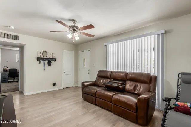 a living room with furniture and a ceiling fan