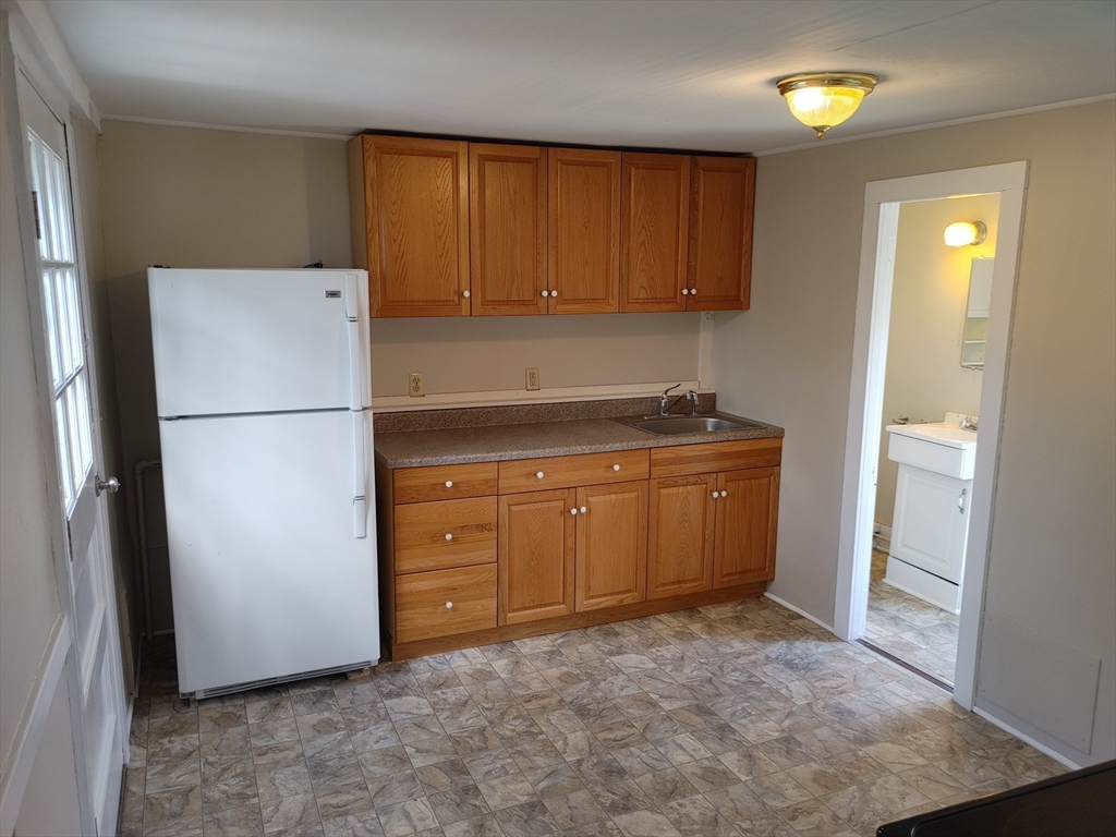 a kitchen with a refrigerator sink and cabinets